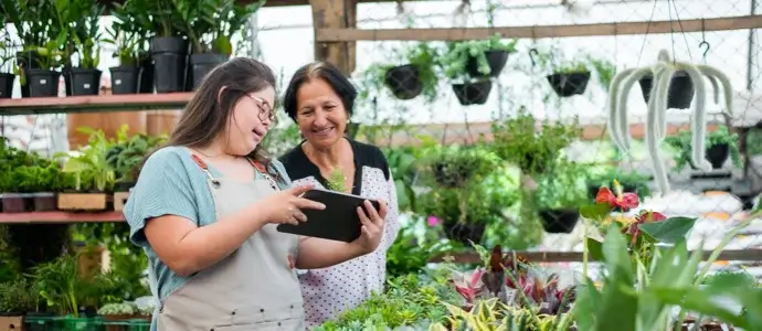 Caretaker helping special needs young adult with job skills